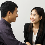A professional meeting room scene where two diverse individuals from different cultural backgrounds are engaged in conversation. One person, representing a high-context culture (e.g., subtle East Asian facial features), is seen with a polite smile and a slight nod, yet their eyes or a subtle body posture convey a deeper, unspoken thought or reservation. The other person, from a more direct, lower-context culture (e.g., Western European or North American appearance), looks slightly confused, missing the implied meaning. The image should subtly highlight the contrast in communication styles, emphasizing the "unspoken" aspects of the high-context individual.